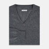 View 4 of product The Turnbull & Asser Storm Grey Cashmere V-neck Jumper features long sleeves, ribbed cuffs and hem—versatile knitwear shown on a white backdrop.