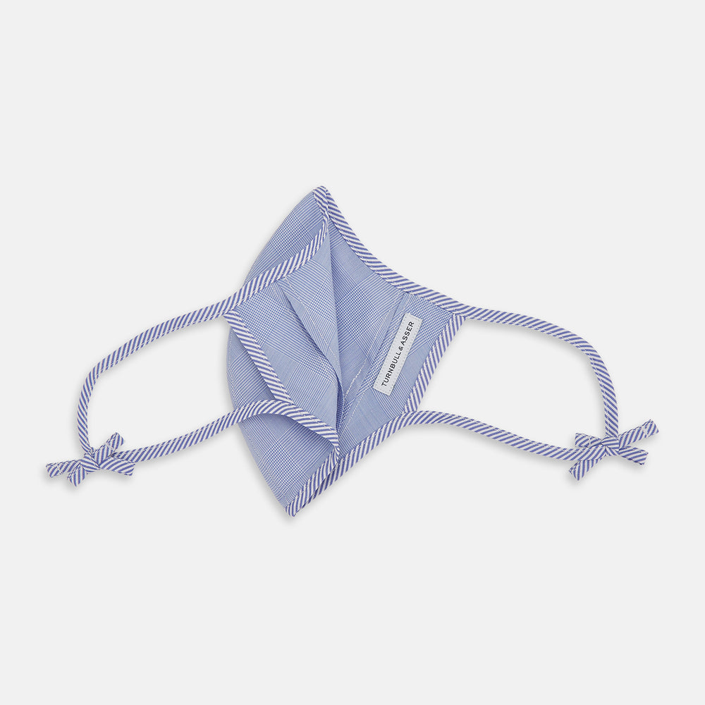 The Turnbull & Asser Blue Fine Check Zephyr Cotton Commuter Mask features a light blue and white check pattern, adjustable side ties, and comes with 3 Viroformula™ filters. Shown on a plain white background.