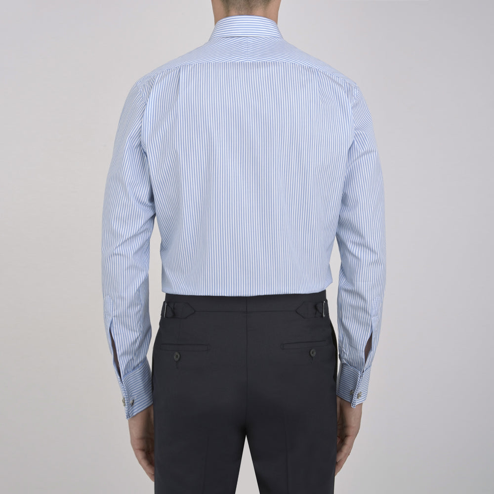 The Turnbull & Asser Light Blue Bengal Stripe Shirt features a classic T&A collar, double cuffs, and white buttons. Made from cotton with blue and white stripes, it's neatly displayed against a plain white background.