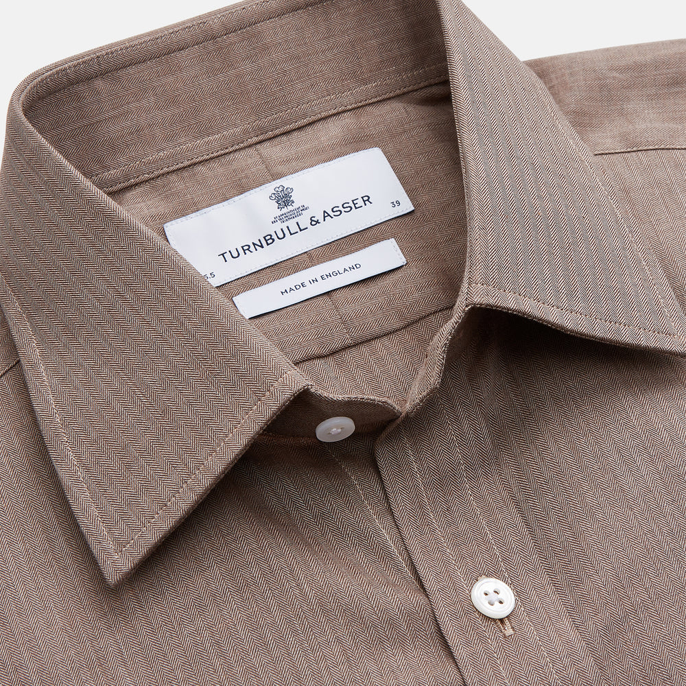 The Turnbull & Asser Camel Cotton Melange Regular Fit Mayfair Shirt features long sleeves, a classic T&A collar, white buttons, and buttoned cuffs in light brown cotton melange, displayed flat on a white background.