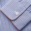 View 3 of product The Blue and Navy Halo Stripe Cotton Sussex Nightshirt by Turnbull & Asser features long sleeves, a collar, button-down front, chest pocket, curved hem, and brown piping for a classic luxury sleepwear style.
