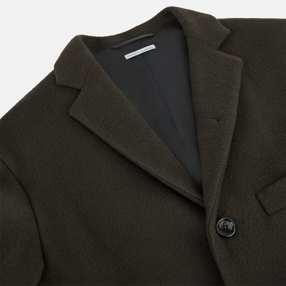 The Turnbull & Asser Olive Brown Apsley Single-Breasted Caban Coat for men features three buttons, notched lapels, and three front pockets, shown against a plain white background.
