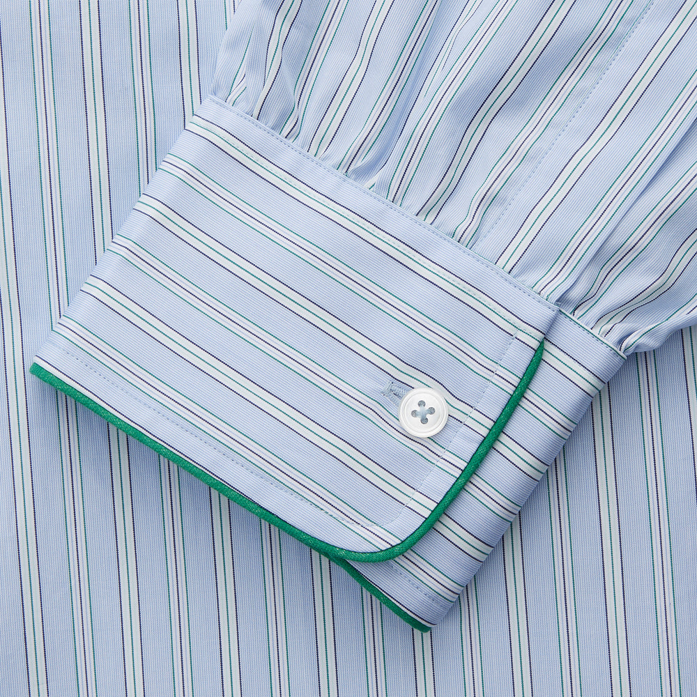 The Turnbull & Asser Blue and Green Stripe Poplin Cotton Nightshirt features long sleeves, a rounded hem, front pocket, green-trimmed collar and pocket, and front buttons—ideal men's nightwear for any season.