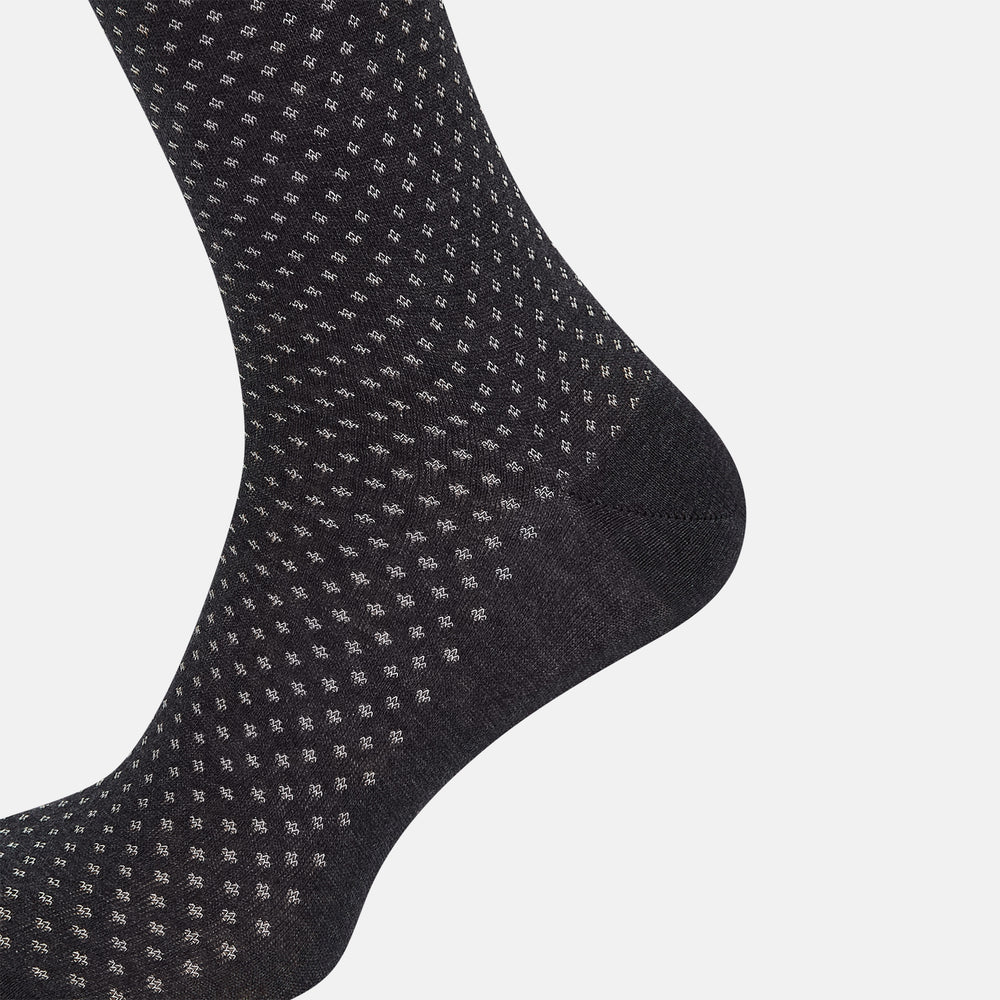 Turnbull & Asser Grey Motif Mid-Length Sock, crafted from Egyptian cotton, features a fine white geometric dot pattern on grey with a solid black cuff, heel, and toe for classic style. Displayed on a white background.
