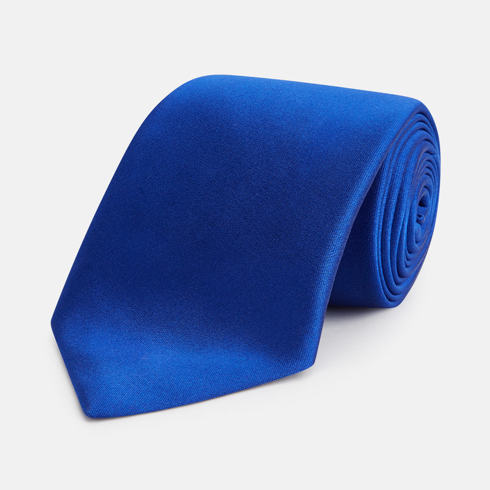The Turnbull & Asser SATIN CRUISE TIE, in vibrant royal blue with a smooth, lustrous finish, creates a striking contrast against a plain white background.