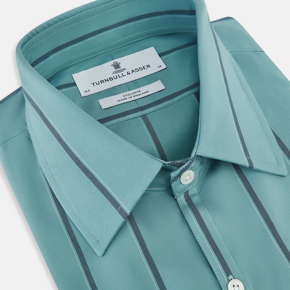 The Turnbull & Asser Sage Track Stripe Westminster Shirt features long sleeves, a tailored fit, a collar, and vertical dark blue stripes, with button closures down the front and at the cuffs, shown laid flat on a white background.
