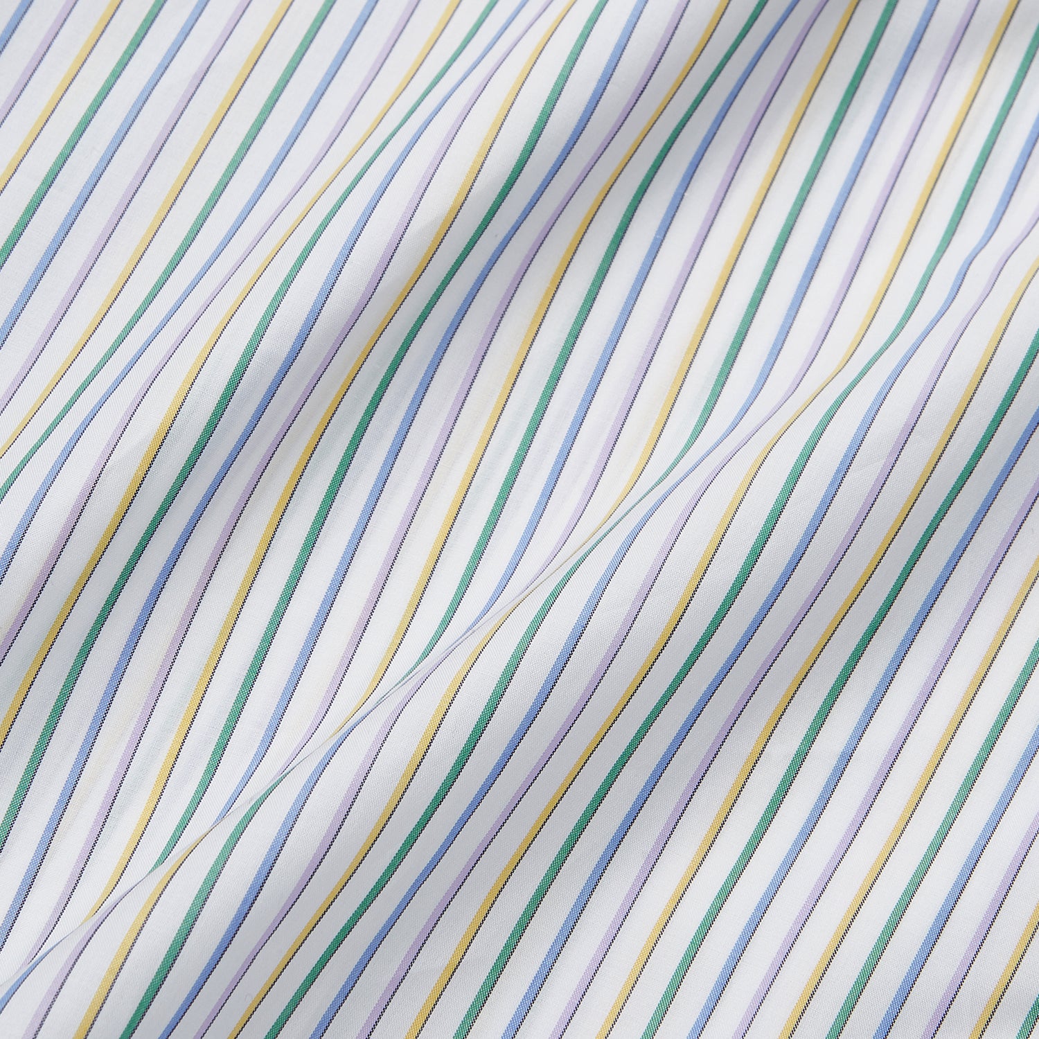 View 6 of product A man wears the Turnbull & Asser Yellow Multi Blazer Stripe Weekend Fit Suffolk Shirt, standing against a beige background with his hands relaxed—a casual look perfect for weekends.
