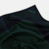 View 2 of product The Turnbull & Asser Navy and Green Dot Silk Pocket Square features dense green polka dots on navy silk, a solid navy border, and a band of spaced green dots—expertly handmade with precise finishing for an elegant look.