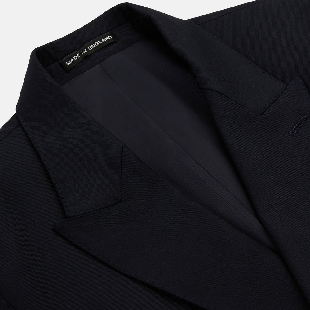 The Classic Navy Wool Blazer by Turnbull & Asser features a double-breasted design, gold buttons, notched lapels, and multiple front pockets, shown on a white background. This piece offers timeless, sophisticated nautical style.