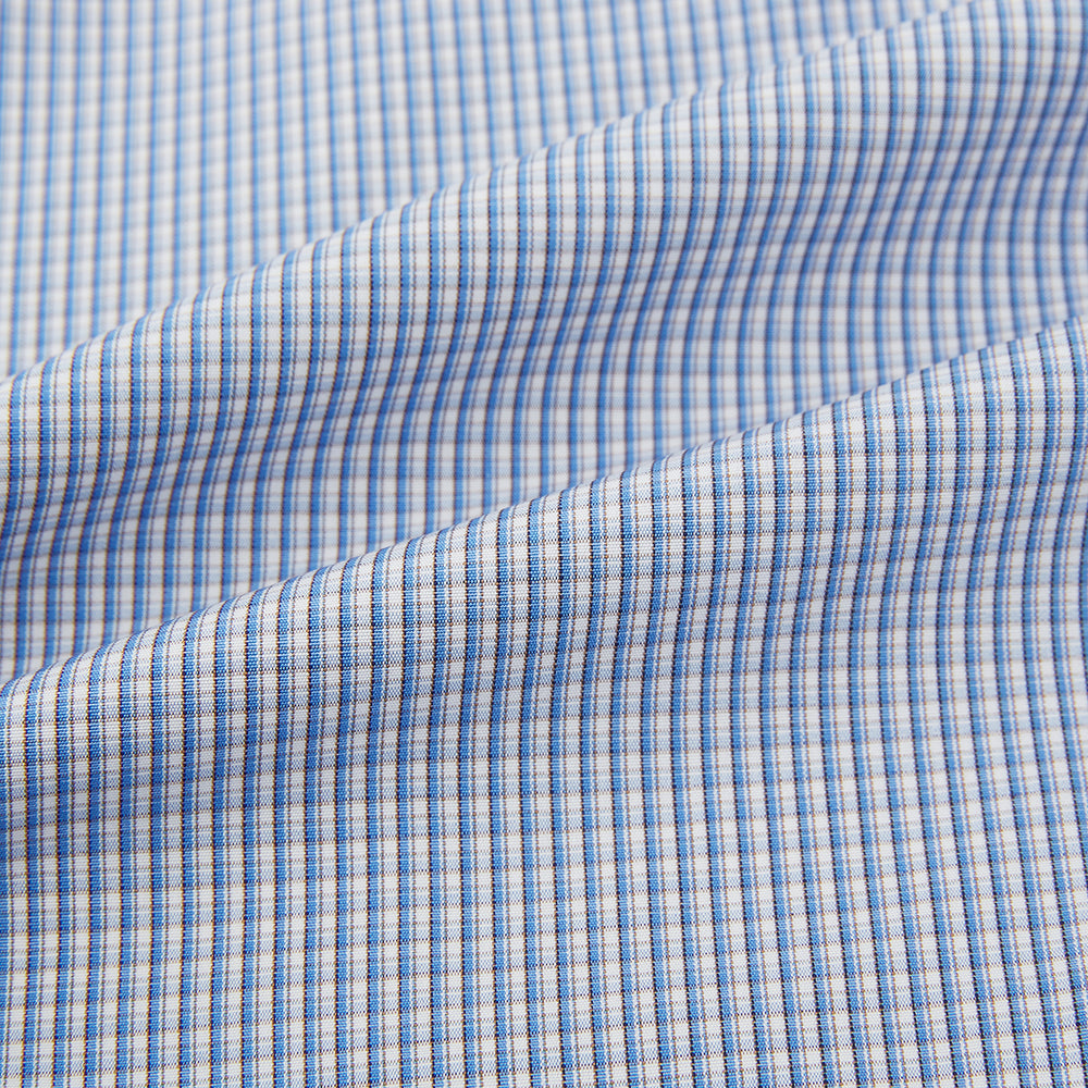 The Turnbull & Asser Pale Blue Micro Graph Check Mayfair Shirt features a small blue and white check pattern, classic T&A collar, white buttons, and buttoned cuffs. Presented on a plain white background.