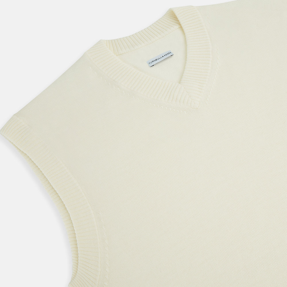 The Turnbull & Asser Cream Fine Merino V-Neck Vest is a sleeveless knit with ribbed edges, ideal for a refined modern look. Shown on a plain white background.