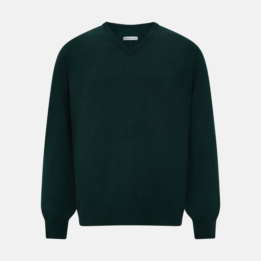 The Turnbull & Asser Petrol Green Merino V-Neck Jumper features long sleeves and ribbed cuffs and hem—an essential knitwear piece, shown against a white background.