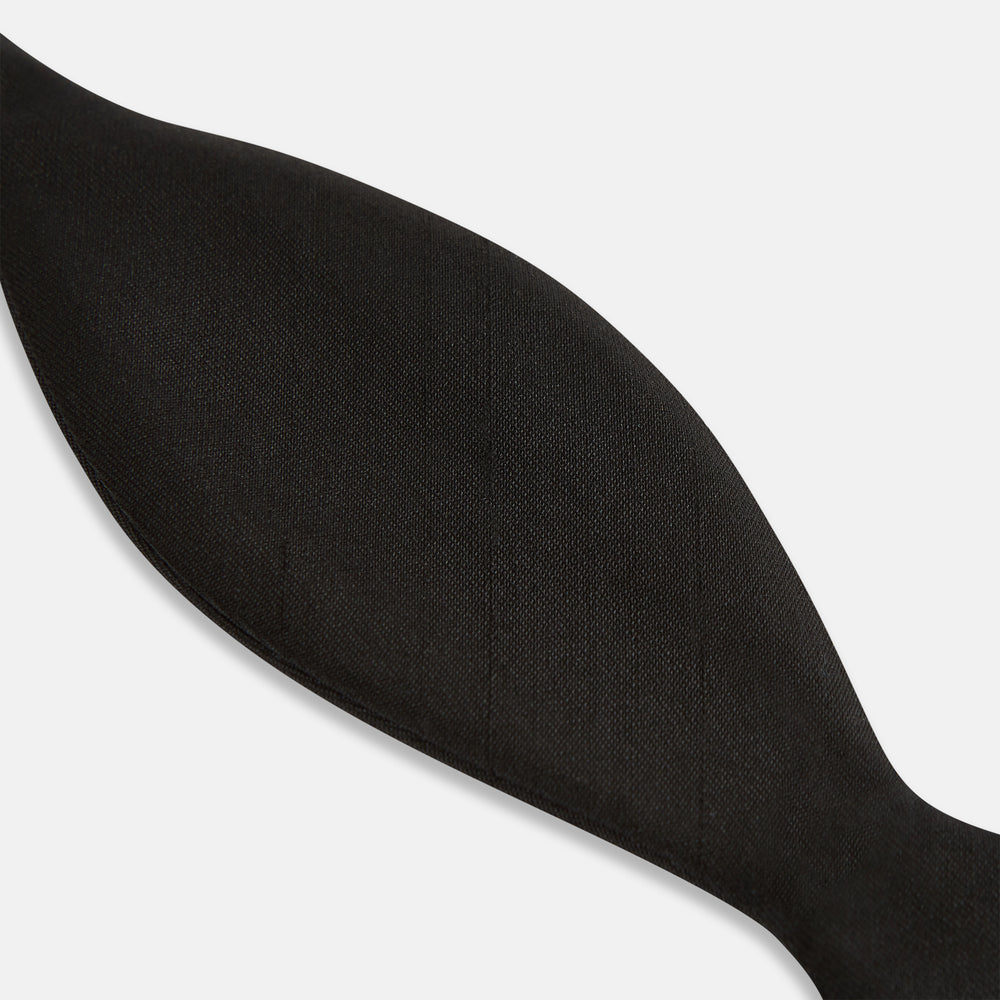 The Casino Royale Bow Tie by Turnbull & Asser, as seen on James Bond, is a classic black Shantung silk bow tie with a smooth, slightly shiny finish, shown against a plain white background.