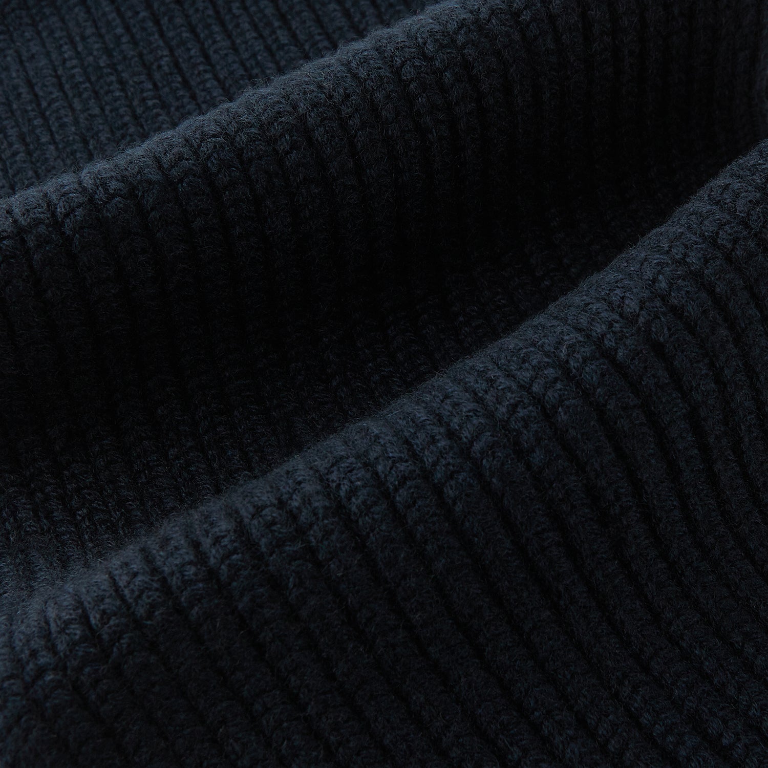 Image 3 of product The Navy Rib-Knit Cashmere Scarf by Turnbull & Asser is neatly folded and looped in a simple knot against a white background, highlighting its refined luxury appeal.