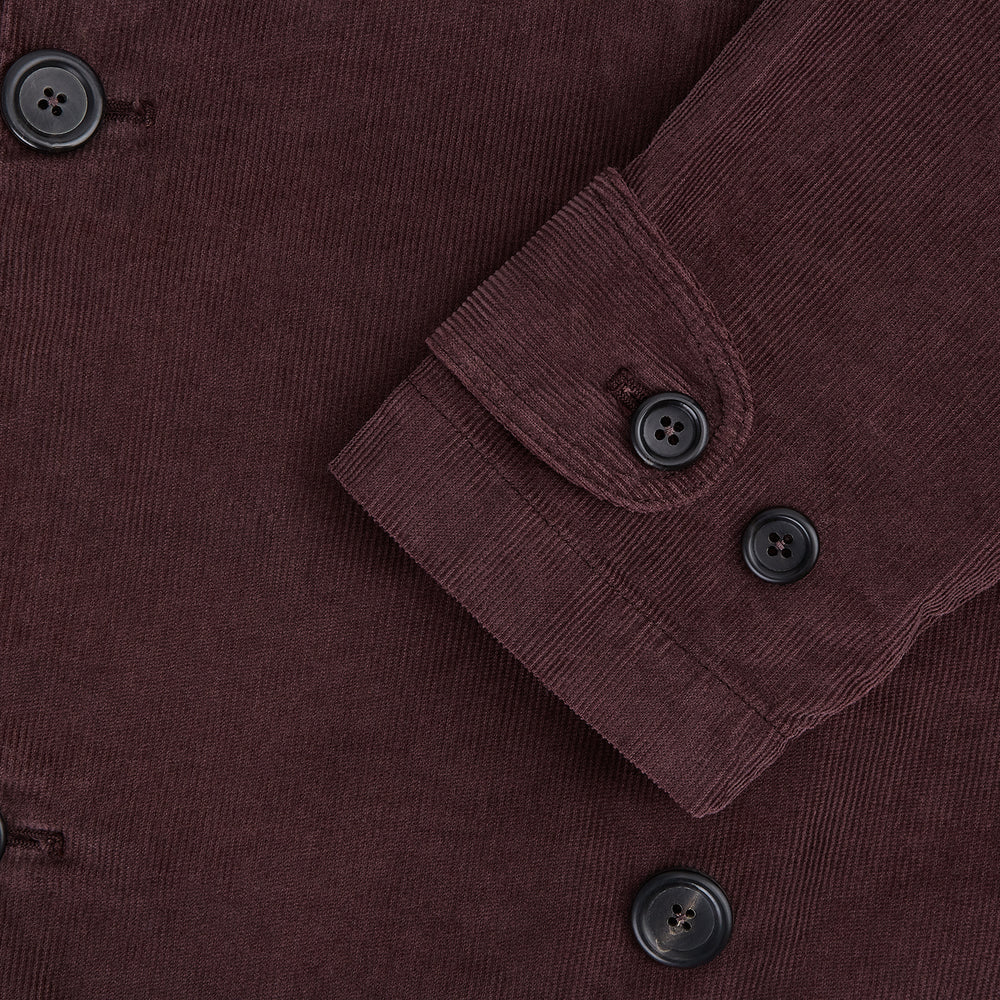 The Burgundy Kingston Corduroy Caban Jacket by Turnbull & Asser features black buttons, a notched collar, and front pockets. Crafted from premium cotton, it is shown on a plain white background.