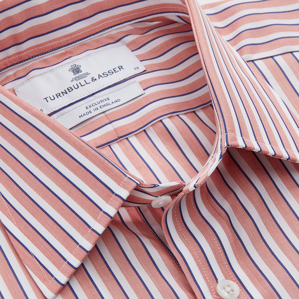 The Turnbull & Asser Orange and White Stripe Cotton Regular Fit Mayfair Shirt features vertical stripes, a classic collar, and buttoned cuffs—an essential men’s wardrobe piece, shown laid flat on a white background.