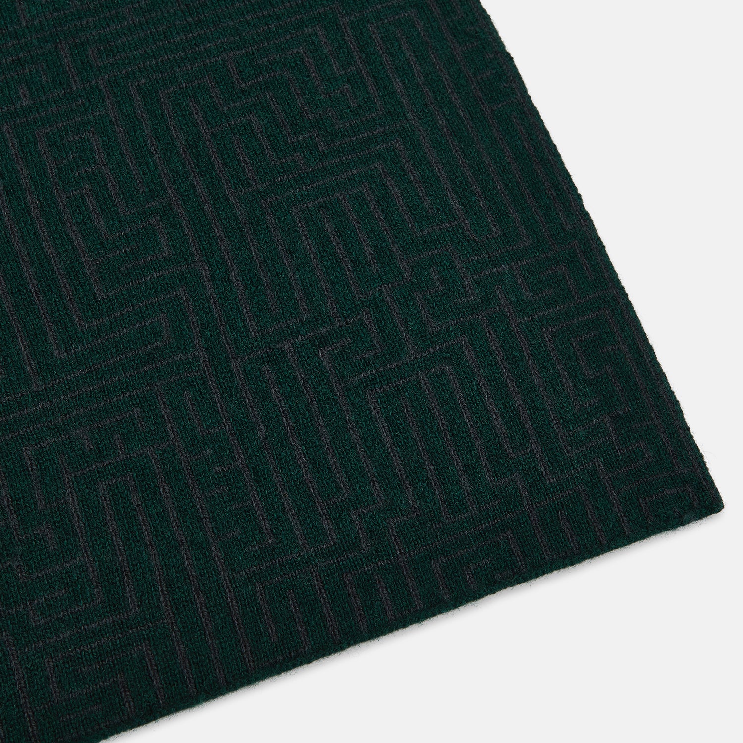 Image 2 of product The Turnbull & Asser Forest Green and Charcoal Fretwork Cashmere Knitted Scarf, featuring a subtle geometric pattern, is neatly folded and knotted against a plain white background.