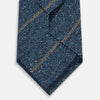 View 3 of product The Blue Multi Stripe Silk Tie by Turnbull & Asser, featuring navy and cream stripes on blue English silk, is shown rolled up against a white background.