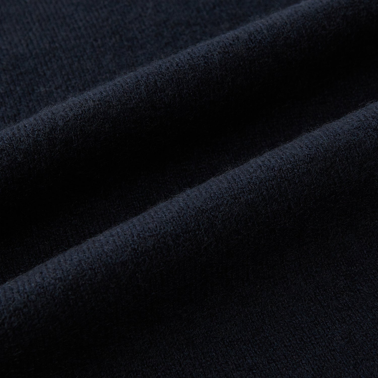 Image 3 of product The Turnbull & Asser Plain Navy Cashmere Knitted Scarf is shown looped against a white background, highlighting its soft texture and elegant drape.