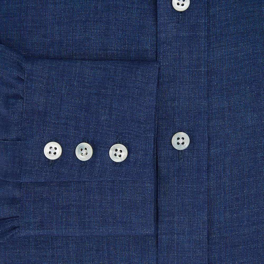 The Turnbull & Asser Navy Linen Mayfair Shirt features long sleeves, a button-up front with white buttons, pointed collar, buttoned cuffs, and a classic fit in solid dark blue linen, shown on a white background.