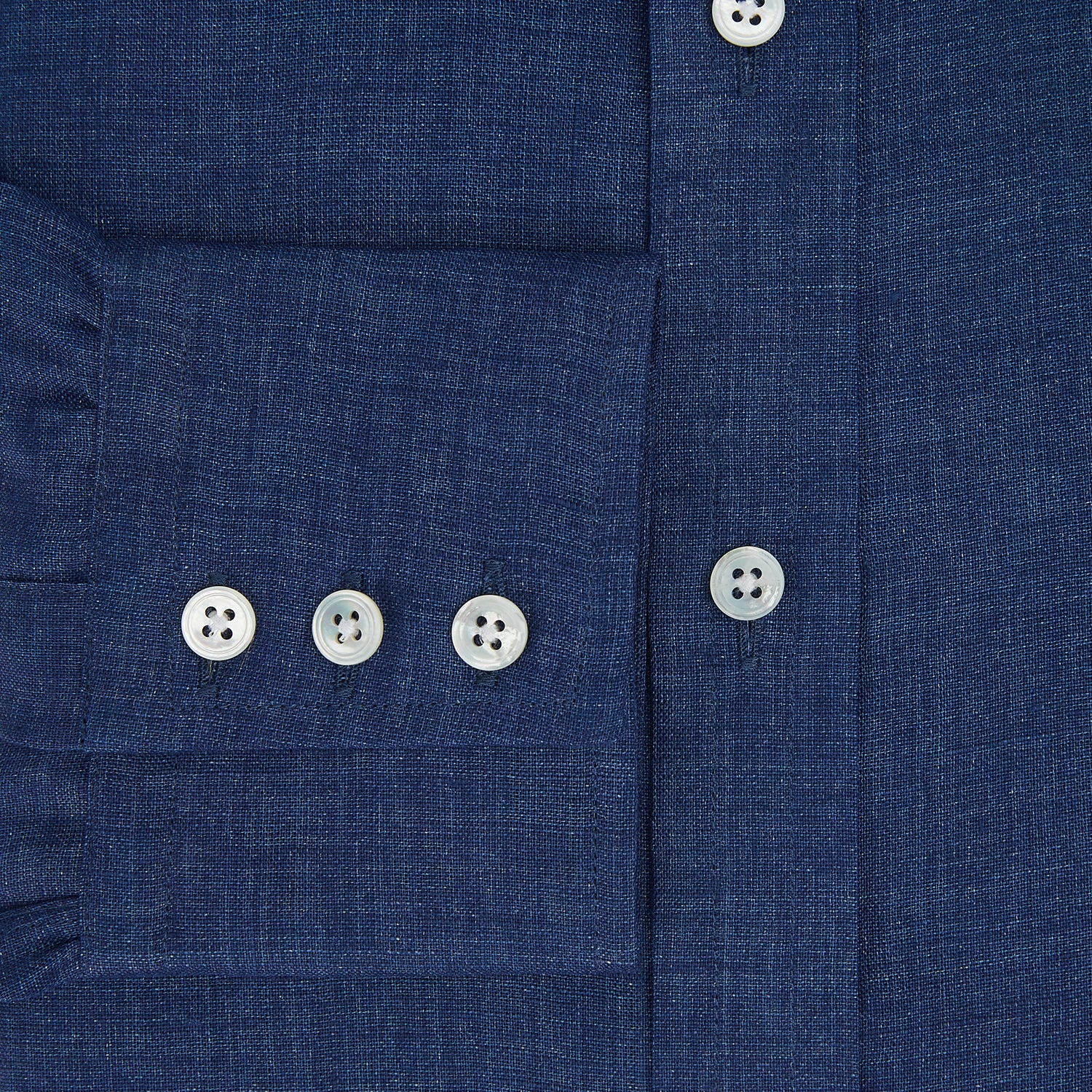 View 4 of product The Turnbull & Asser Navy Linen Mayfair Shirt features long sleeves, a button-up front with white buttons, pointed collar, buttoned cuffs, and a classic fit in solid dark blue linen, shown on a white background.