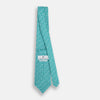 View 4 of product The Turnbull & Asser Turquoise Flower Patterned Printed Silk Tie, crafted from fine English silk, is neatly rolled on a white background.