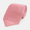 View 1 of product The Turnbull & Asser Pink and White Houndstooth Silk Tie features a small pattern and is displayed rolled up on a plain white background, making it perfect for pairing with any office shirt.