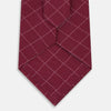 View 3 of product The Turnbull & Asser Burgundy Dotted Check Pattern Printed Silk Tie is shown rolled up on a plain white background.
