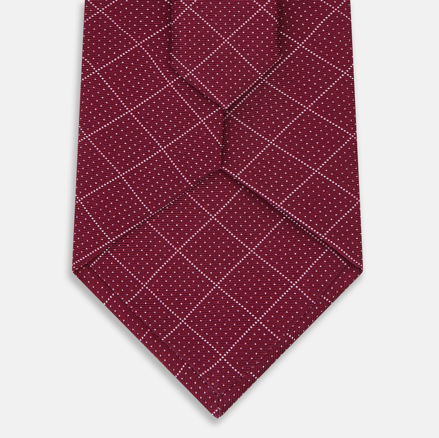 View 3 of product The Turnbull & Asser Burgundy Dotted Check Pattern Printed Silk Tie is shown rolled up on a plain white background.