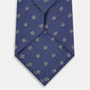 View 3 of product The Turnbull & Asser Navy Circle Silk Tie, made from pure silk with a navy base and small white dot pattern, is shown rolled up on a plain white background.