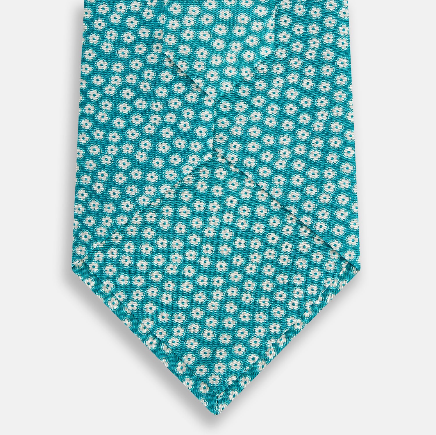 View 3 of product The Turnbull & Asser Turquoise Flower Patterned Printed Silk Tie, crafted from fine English silk, is neatly rolled on a white background.