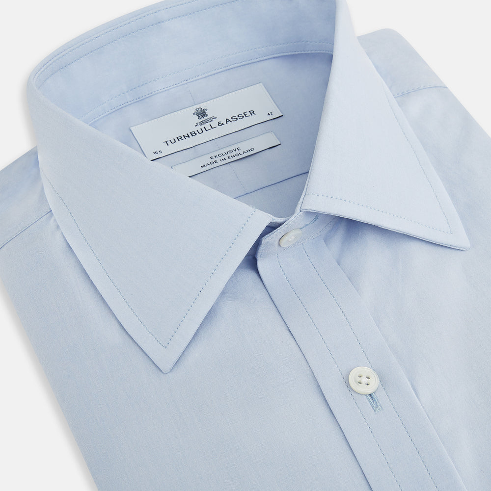 The Pale Blue Mayfair Shirt by Turnbull & Asser is a long-sleeve, button-up dress shirt with a pointed collar and buttoned cuffs, crafted from sanforised cotton and shown laid flat on a white background.