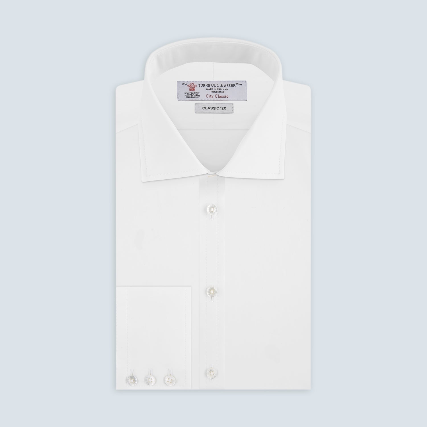 View 4 of product The Turnbull & Asser Two-Fold 120 White Shirt with a Regent collar and 3-button cuffs is neatly folded and displayed against a light blue background.