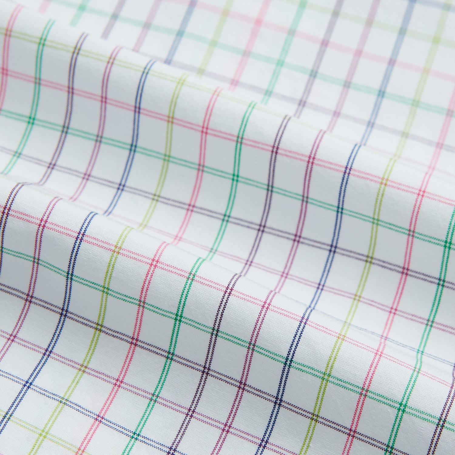 View 6 of product The Turnbull & Asser Multicoloured Double Grid Check Mayfair Shirt, made from organic cotton, features long sleeves, a collar, and a blue, green, and red grid check on white. The shirt is shown neatly laid flat against a white background.
