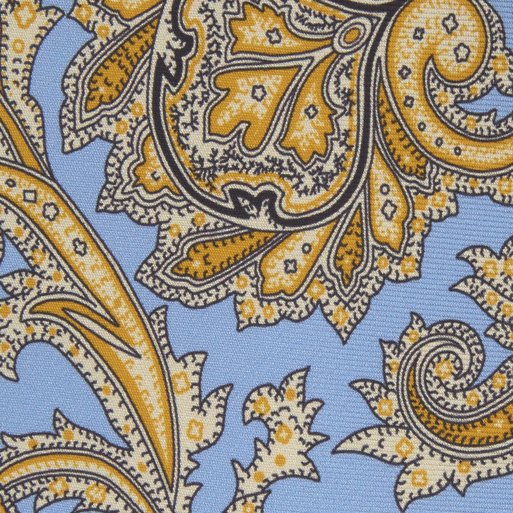 The Turnbull & Asser GGT92000 3062 06 OS is a rolled-up necktie with an intricate blue and yellow paisley pattern on a light blue background—a stylish accessory for any wardrobe.