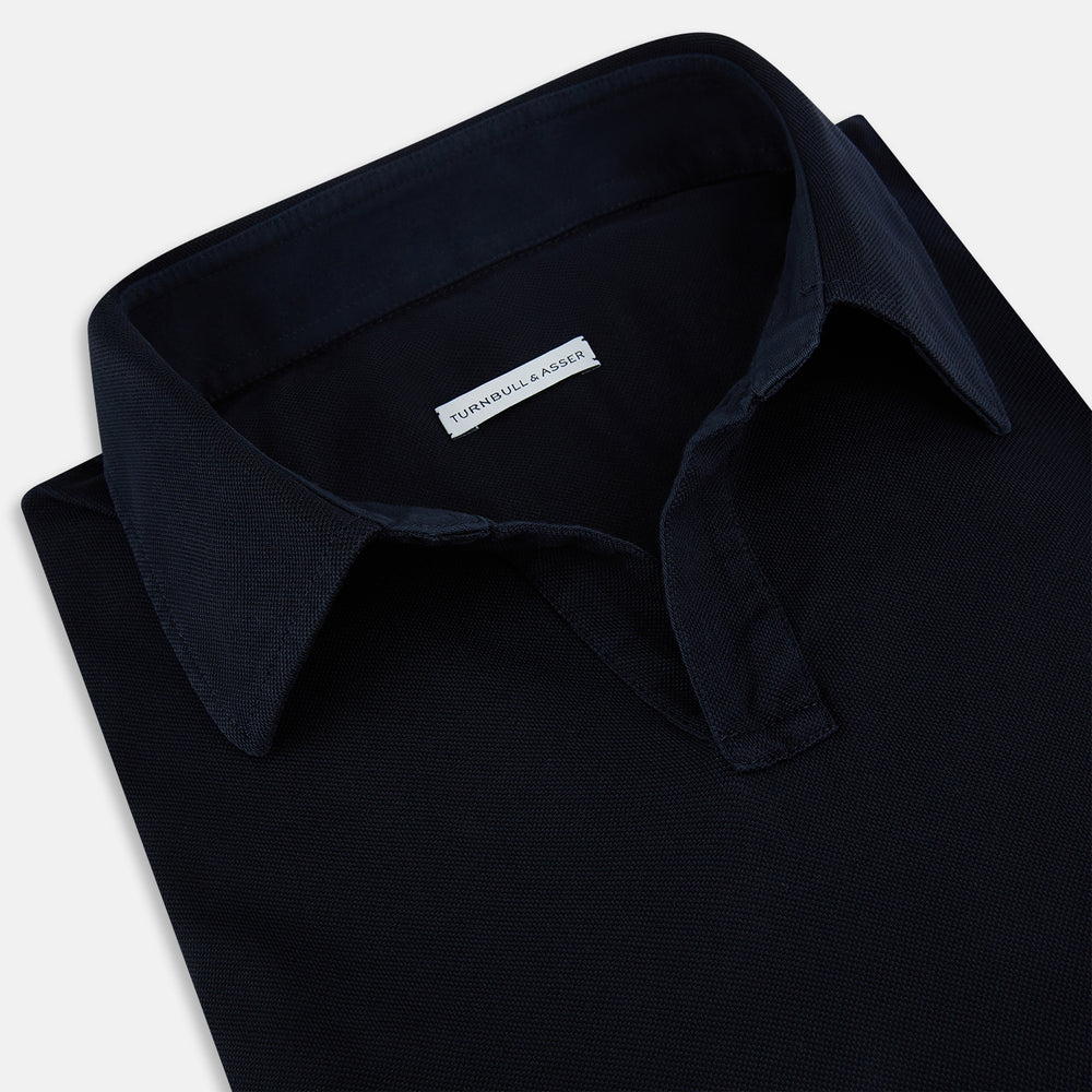 A Navy Rugby Polo Shirt by Turnbull & Asser, featuring long sleeves and a collar, is displayed flat on a white background. The design is simple and free of visible logos or patterns.