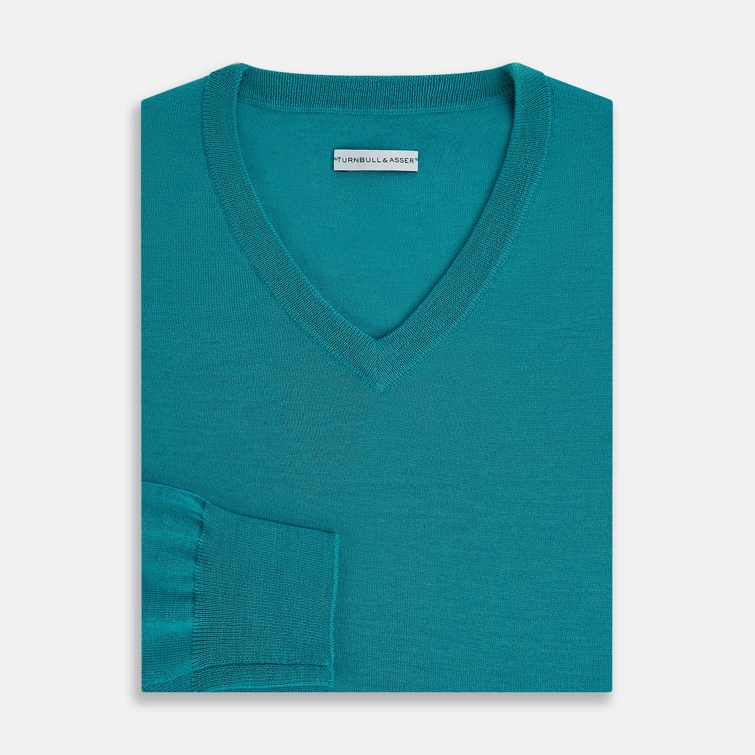 View 4 of product The Turnbull & Asser Turquoise Fine Merino V-Neck Jumper features long sleeves, ribbed cuffs and waistband, shown on a white background—a timeless choice for classic knitwear enthusiasts.