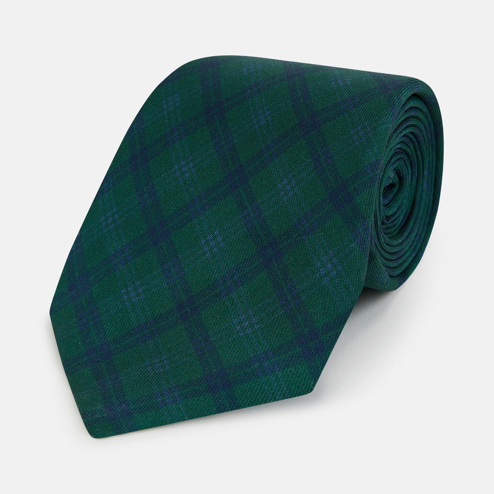The Turnbull & Asser Forest Melange Tartan Plaid Silk Tie features a classic green and blue plaid design, rolled up and displayed on a plain light background—reflecting timeless Scottish heritage.