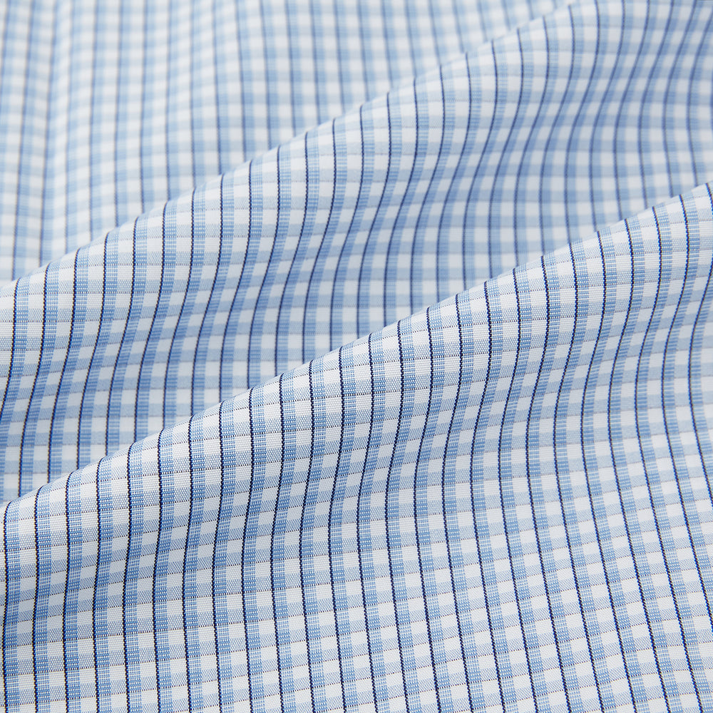 The Turnbull & Asser Blue Micro Shadow Check Mayfair Shirt features a long-sleeve, button-up design with a small blue and white check pattern, pointed T&A collar, and classic cuffs.
