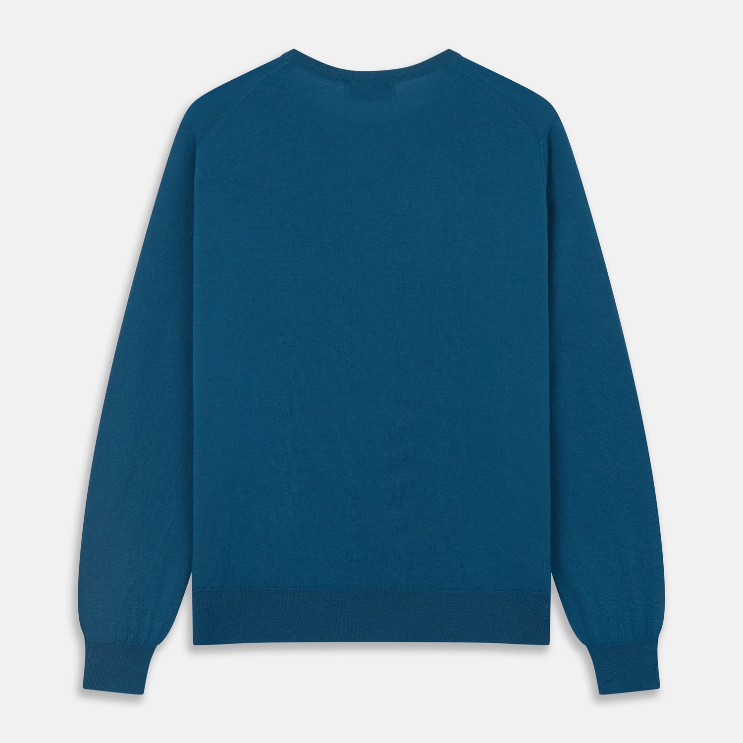 View 4 of product A man with light skin and short brown hair stands against a plain background, wearing the Turnbull & Asser Ocean Blue Merino Kingston Crew Neck Jumper and cream-colored pants, looking directly at the camera with a neutral expression.