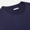 View 2 of product The Turnbull & Asser Navy Merino Round Neck Jumper is shown against a light gray background, featuring a classic long-sleeve design with ribbed cuffs, hem, and neckline for timeless style.