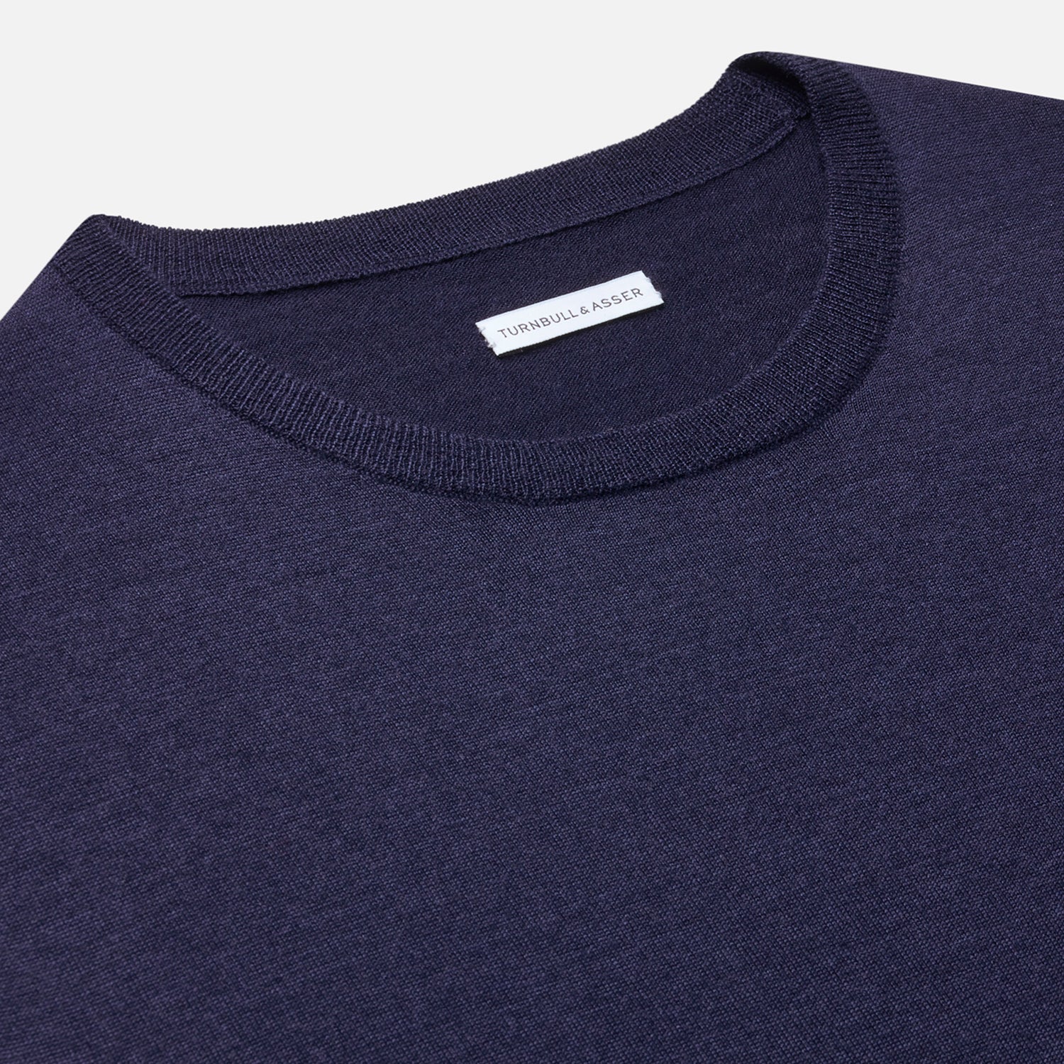 View 2 of product The Turnbull & Asser Navy Merino Round Neck Jumper is shown against a light gray background, featuring a classic long-sleeve design with ribbed cuffs, hem, and neckline for timeless style.