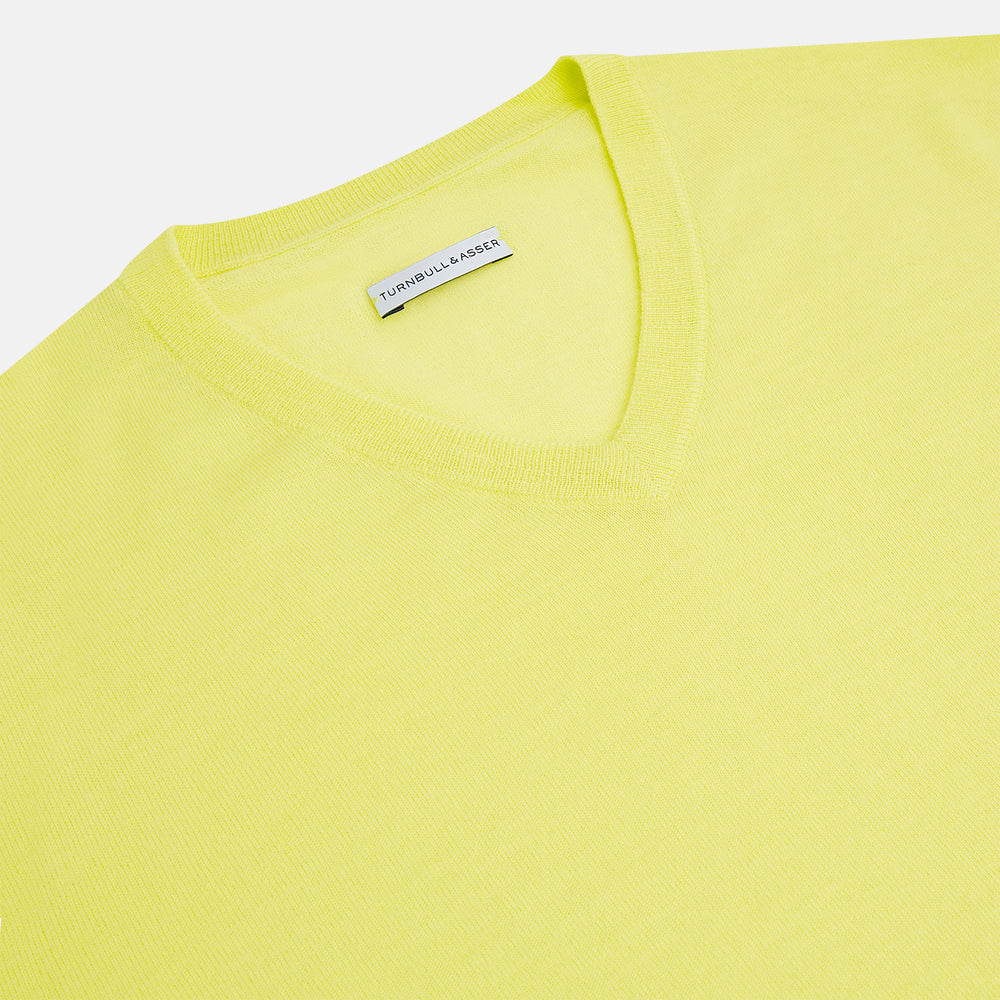 The Turnbull & Asser Bright Yellow Cashmere V-neck Jumper, a plain long-sleeved knitwear sweater, is showcased against a white background.