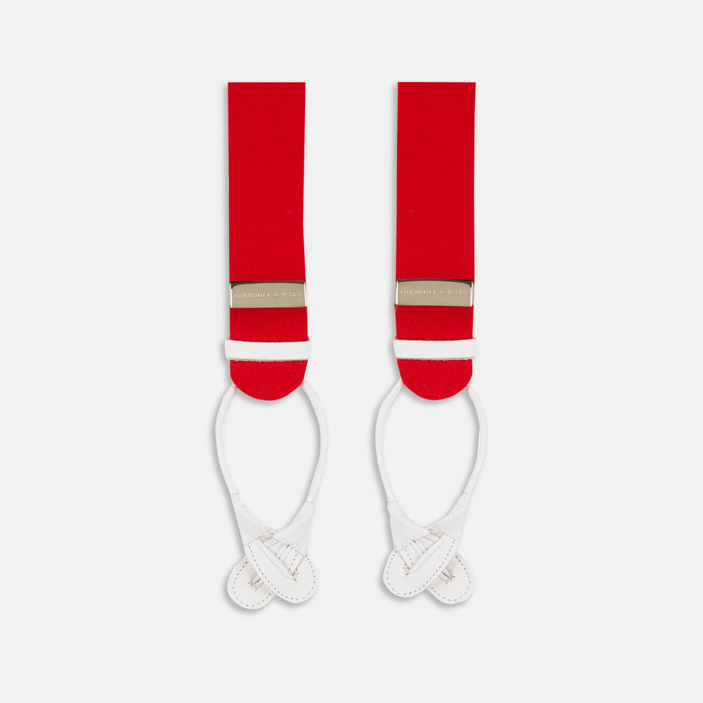 Turnbull & Asser’s Red Adjustable Felt Braces, crafted in England from traditional boxcloth, feature white leather loop ends and silver metal adjusters. The braces are laid flat on a white background.