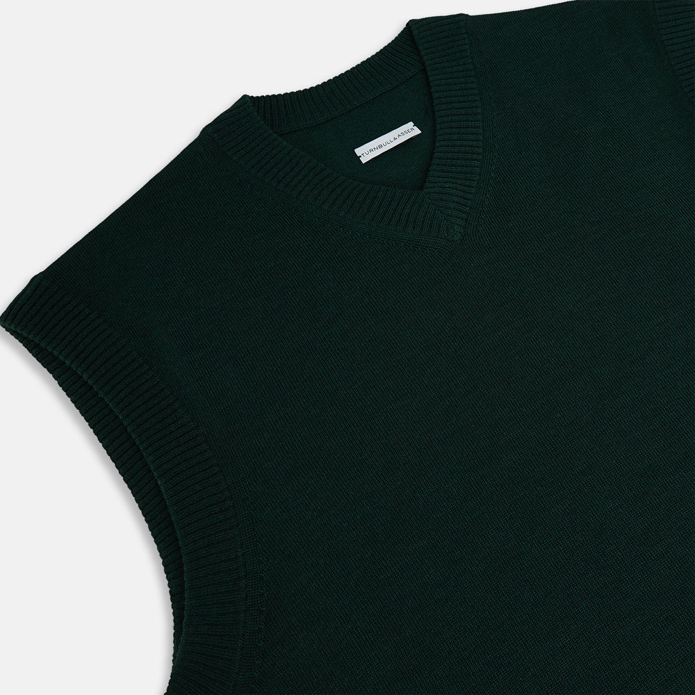 The Turnbull & Asser Forest Green Fine Merino V-Neck Vest is a sleeveless knitwear piece with ribbed edges, shown on a plain white background—ideal for elevating men’s sophisticated wardrobes.