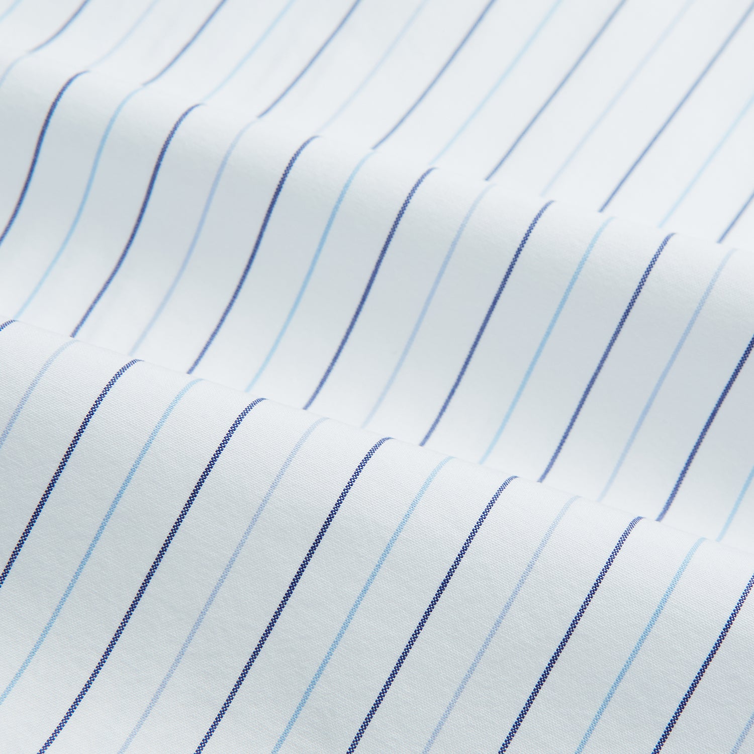 View 6 of product The Turnbull & Asser Blue Wide Pinstripe Mayfair Shirt is a long-sleeved, collared, button-down style crafted from organic cotton, featuring wide blue pinstripes on a white background.