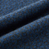 View 3 of product The Azzurro and Graphite Lozenge-Patterned Cashmere Knitted Scarf by Turnbull & Asser features a blue geometric design and luxurious softness, displayed in a looped drape with both ends hanging against a white background.