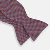 View 2 of product The Indies Red Floral Square-Print Silk Bow Tie by Turnbull & Asser features a geometric blue and white diamond pattern on red silk, styled against a white background for classic British elegance.