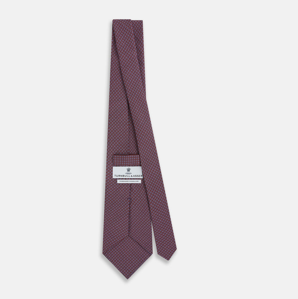 The Turnbull & Asser Indies Red Floral Square-Print Silk Tie is shown rolled up, highlighting its red floral square pattern against a plain white background.