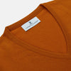 View 2 of product The Rust Ifor Slipover by Turnbull & Asser, a sleeveless V-neck in burnt orange, is made from lightweight Scottish cashmere and displayed flat on a white background.